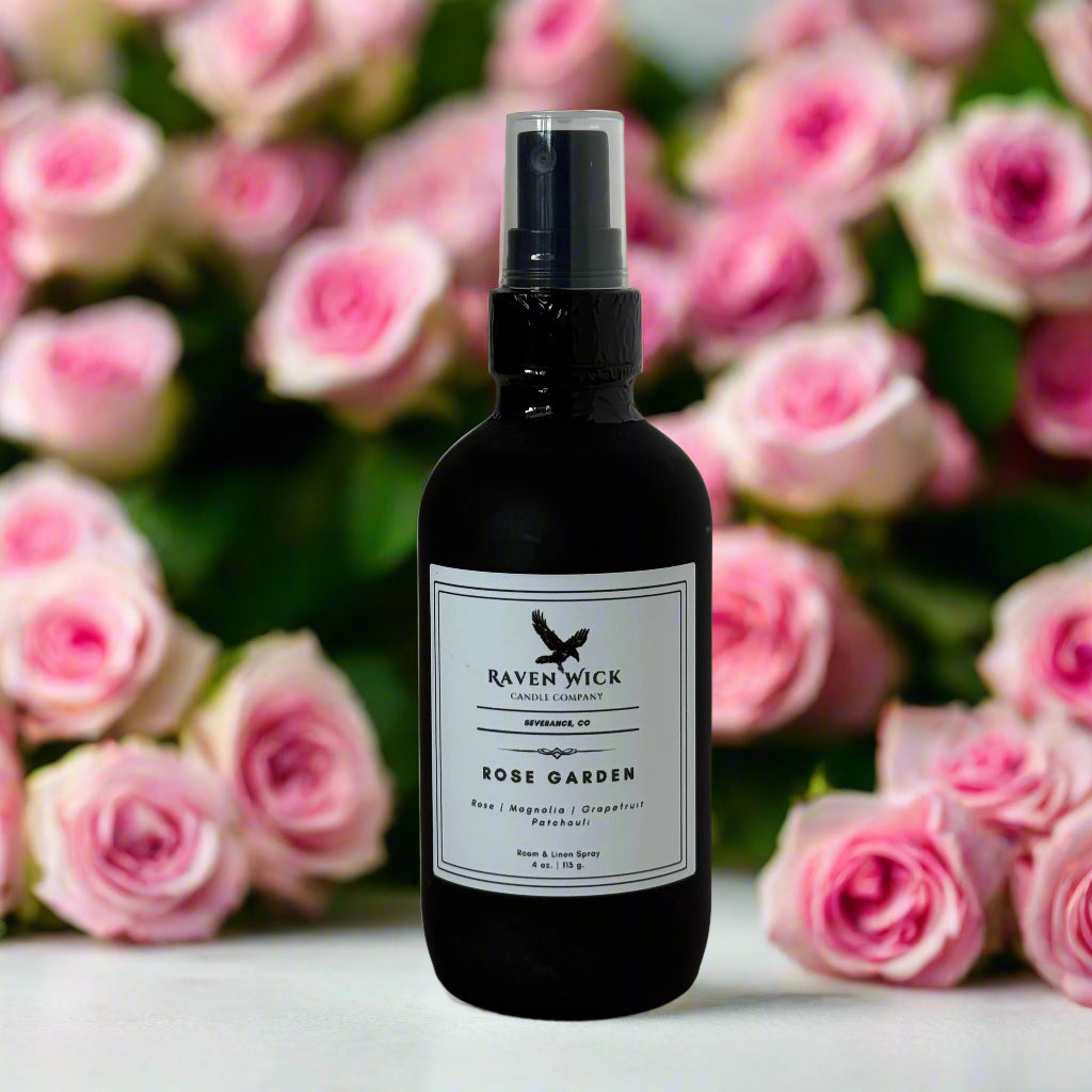 Black spray bottle with a label in front of pink roses